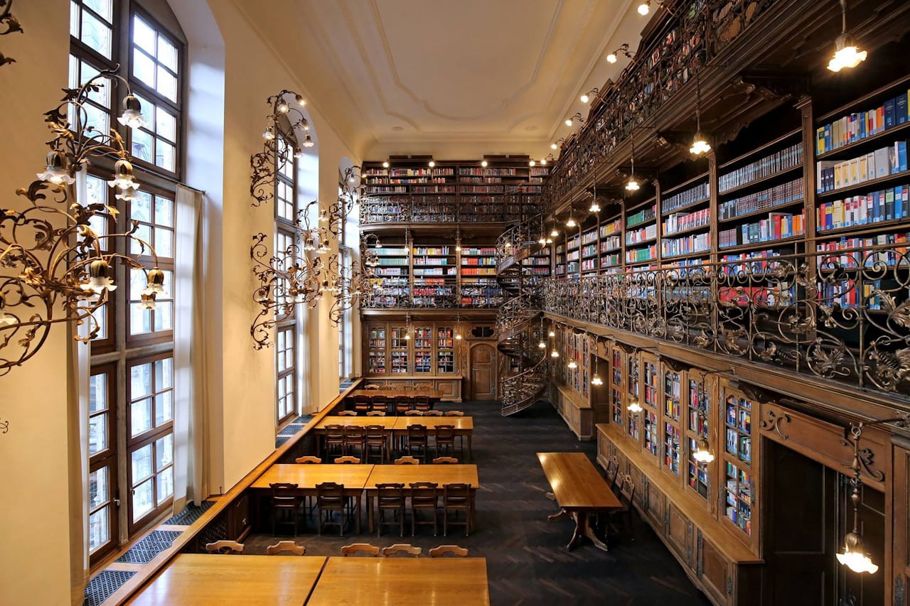 Law Library in Munich Town Hall featuring ornate iron balconies, spiral staircases, and historic bookshelves.