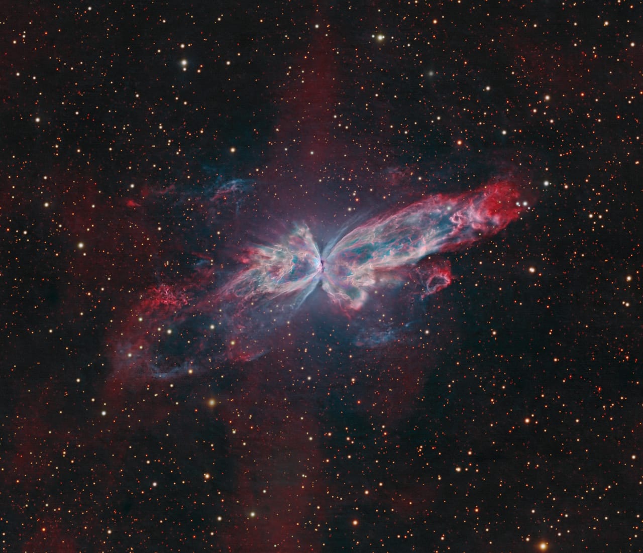 The Butterfly Nebula (NGC 6302) displays intricate knots and filaments in red and blue-green, highlighting its cosmic beauty.