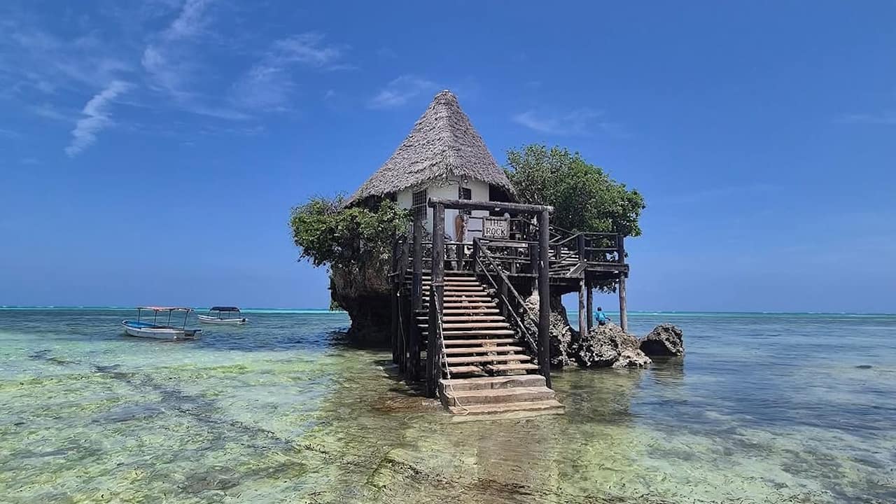 Stairs from a restaurant dropping into the ocean water at low tide.