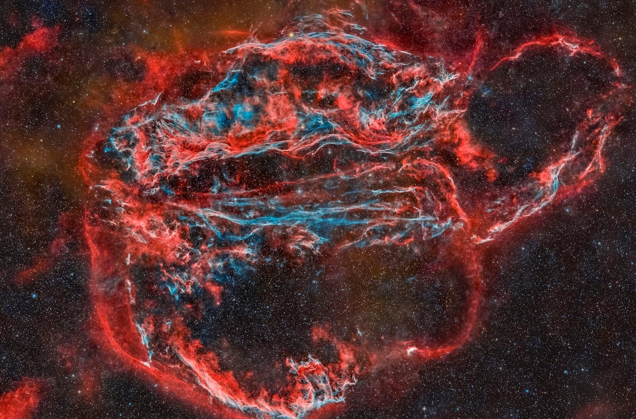 NASA Space Pictures. A stunning view of the Veil Nebula, featuring red and blue wisps, the remnants of a supernova.