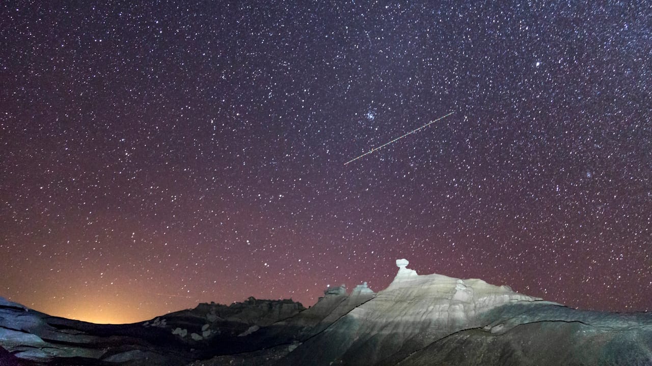 Night time picture of the Pleiades star cluster over Hoodoo Ridge in Petrified Forest National Park Arizona.