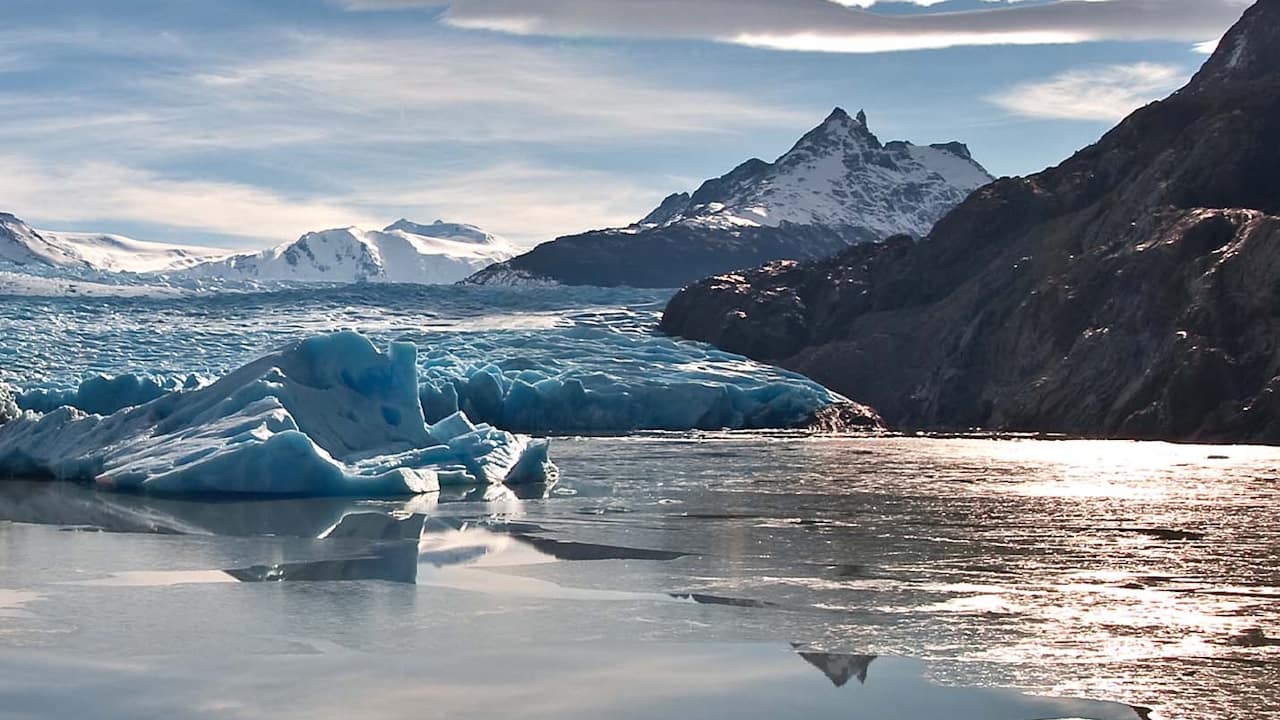 Grey Glacier's reflection shimmers in the water, with the dramatic mountains of Torres del Paine National Park in the backdrop.