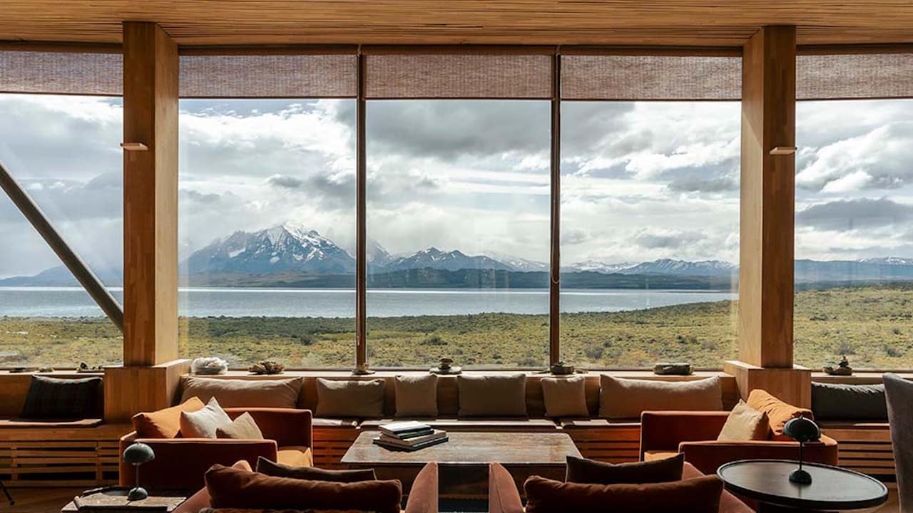 The Tierra Patagonia hotel lounge offers breathtaking views of the majestic Torres del Paine mountains and the tranquil waters of Lake Sarmiento.
