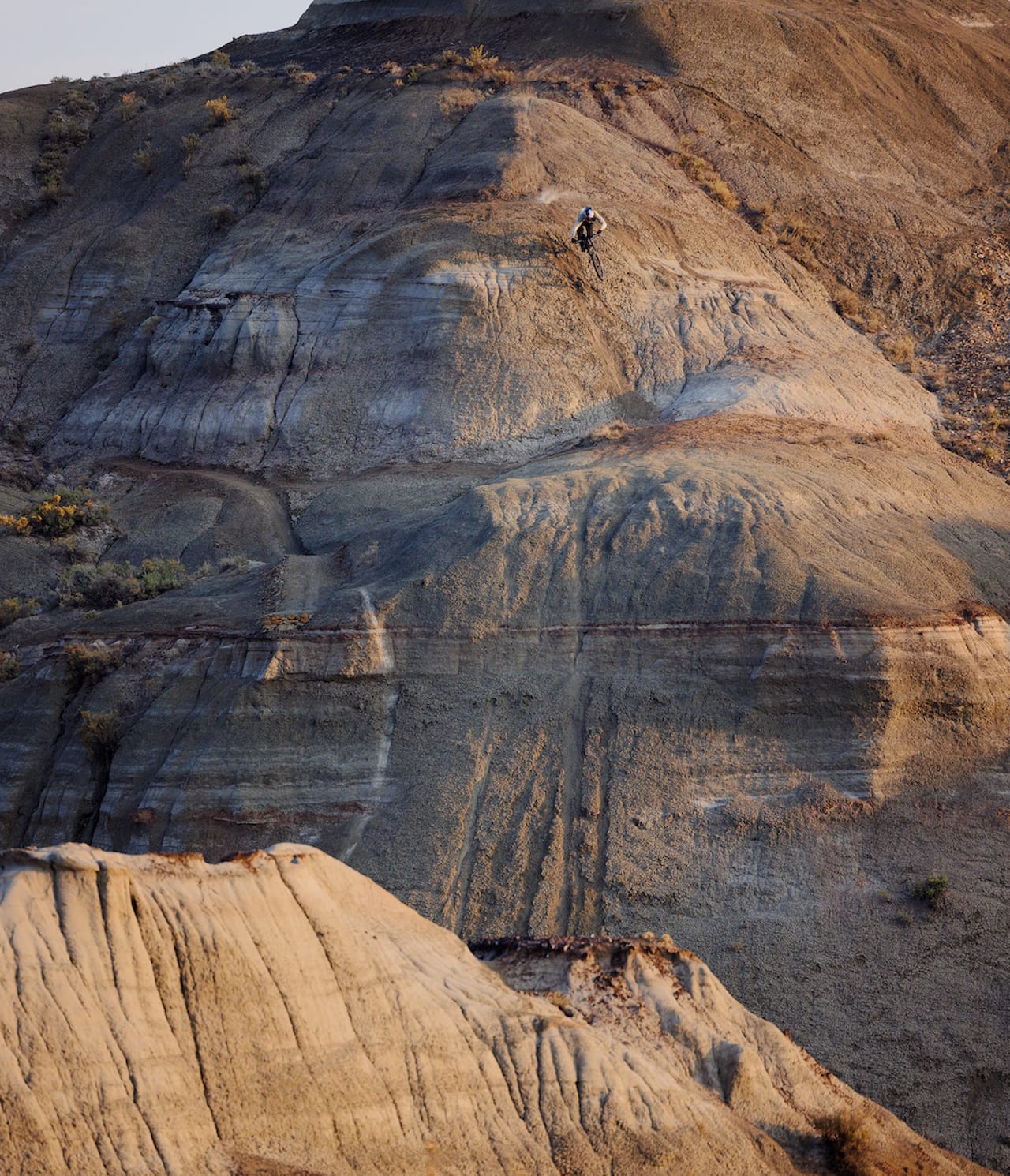 Brandon Semenuk starting a very steep decent down a dirt hill on his mountain bike.