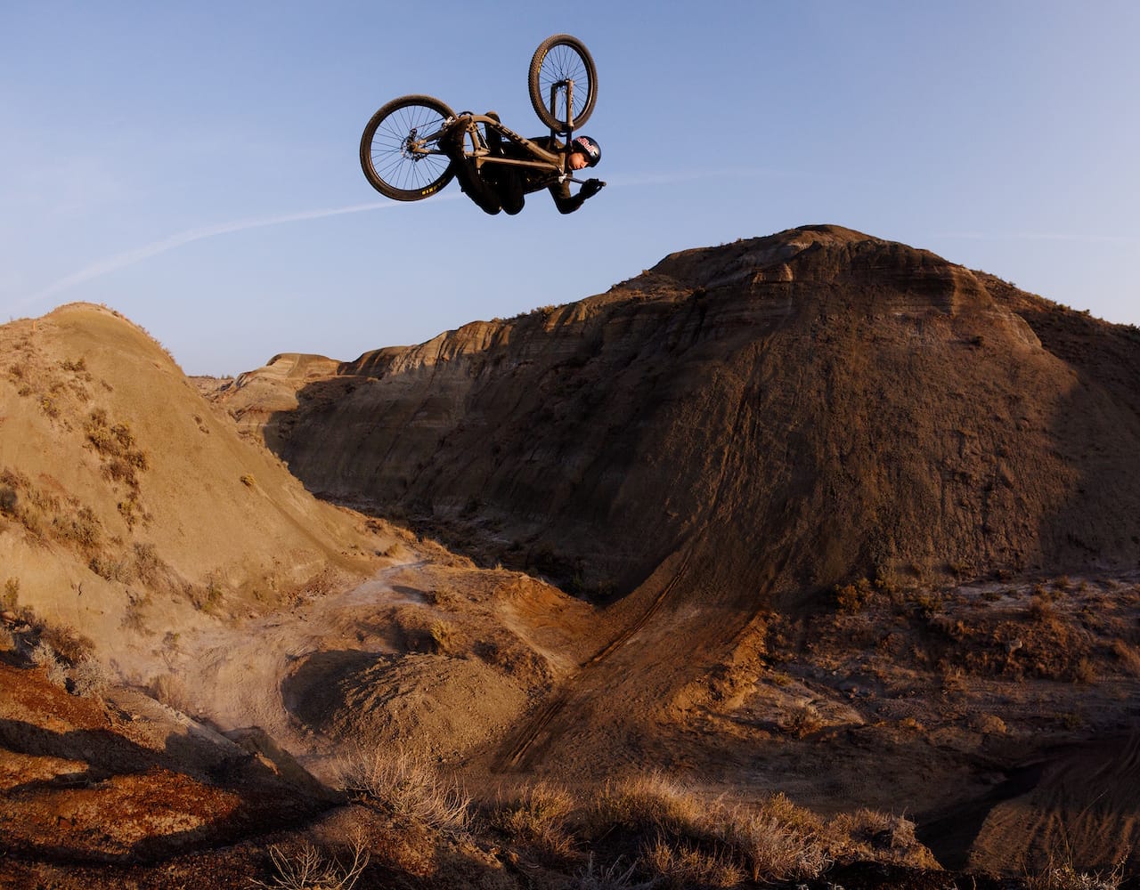 A mountain biker flies through the air doing a freestyle trick.
