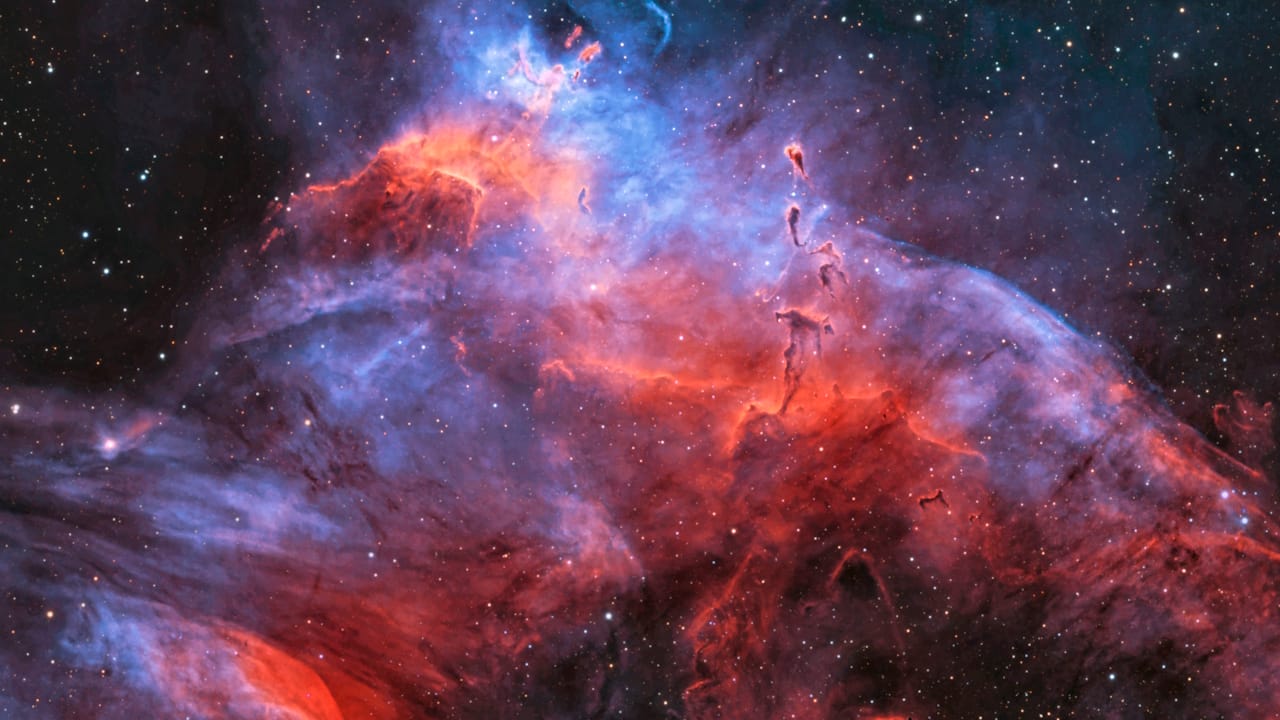 A vibrant cosmic scene of the NGC 3572 Nebula, with glowing gas and dark dust, highlighting young stars in the southern sky.