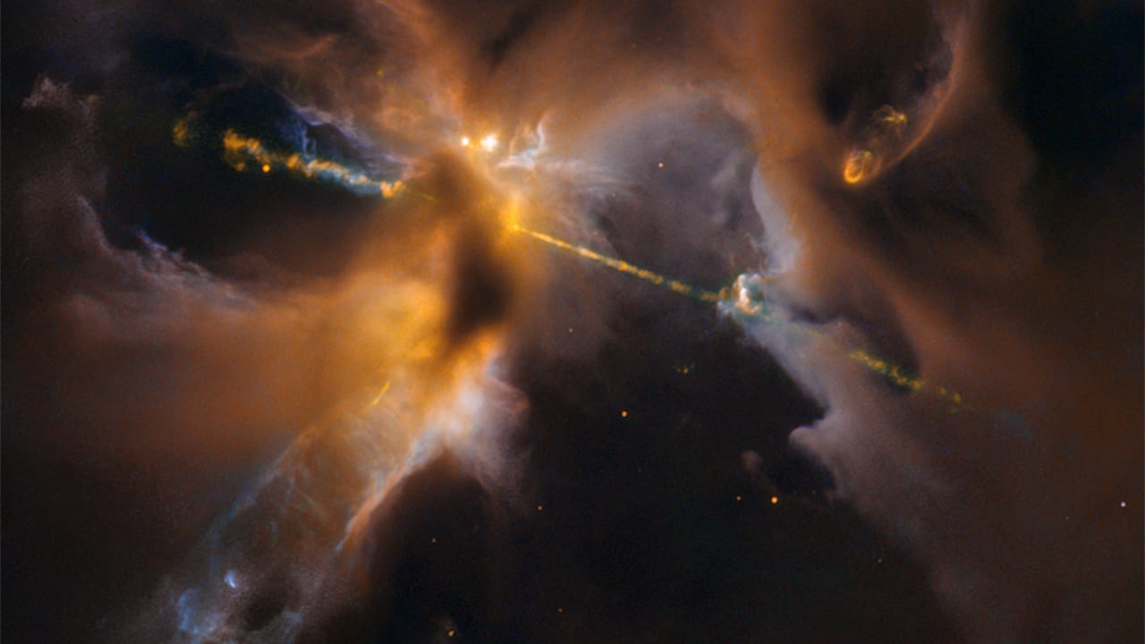 A stunning nebula illuminated by a bright light at its core, featuring energetic jets from a young star in the cosmos.