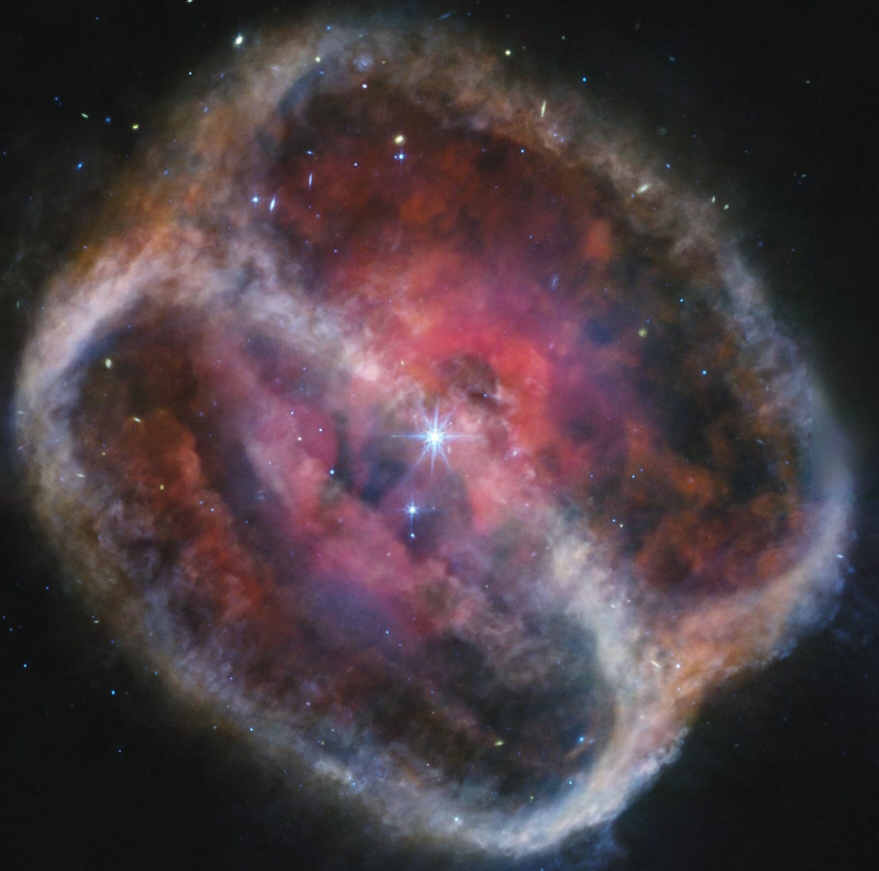 Nebula NGC 1514, a star-forming region, reveals an hourglass shape and a bright central star in this stunning infrared image.