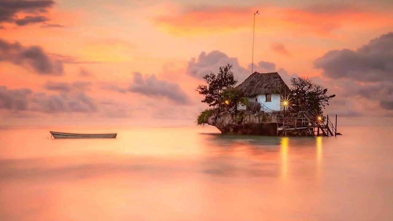 The Rock Restaurant with a spectacular orange sunset in the background.