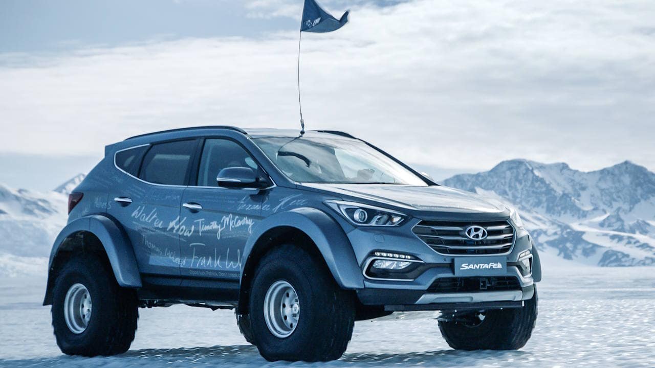 Hyundai Sante Fe modified by Artic Trucks parked on Arctic ice with mountains in the background.