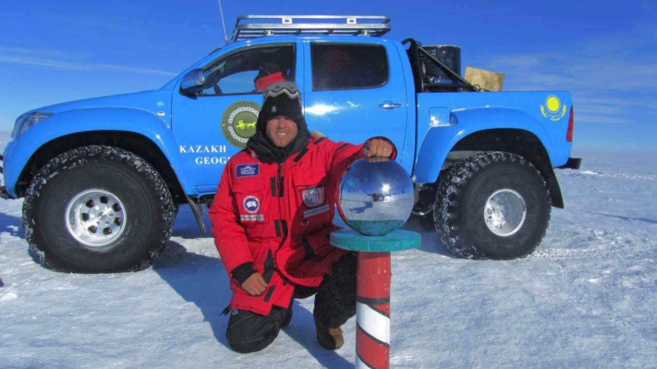 Blue Toyota with 44 inch tires shown at the South Pole marker in 2011.