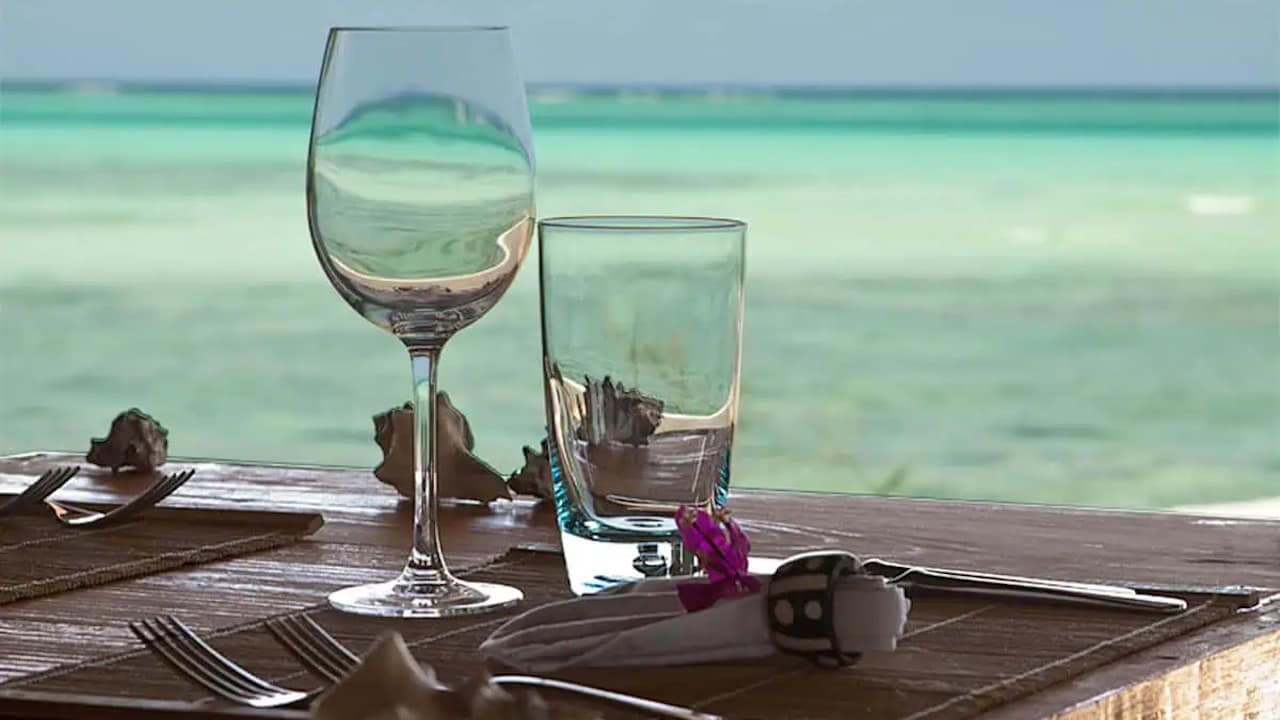 Looking through a wineglass at a table at The Rock Restaurant towards the open ocean.