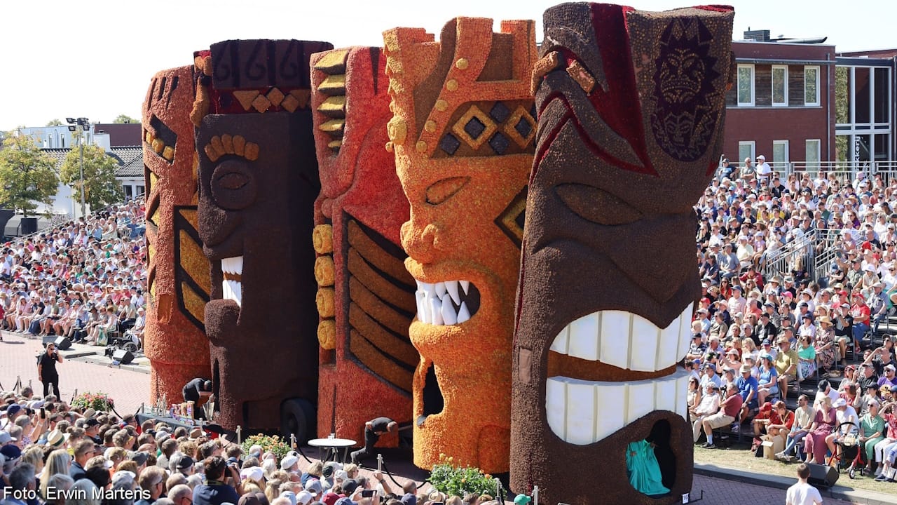Brilliant Zundert Flower Parade float depicting five grinning totems in orange and brown.