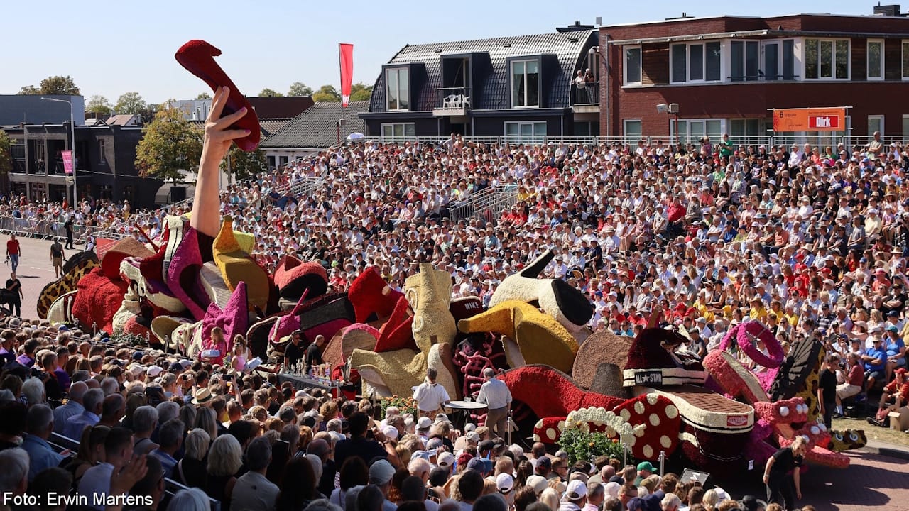 Brilliant flower parade float showing a pile of shows with a hand holding up the one shoe that had been lost.