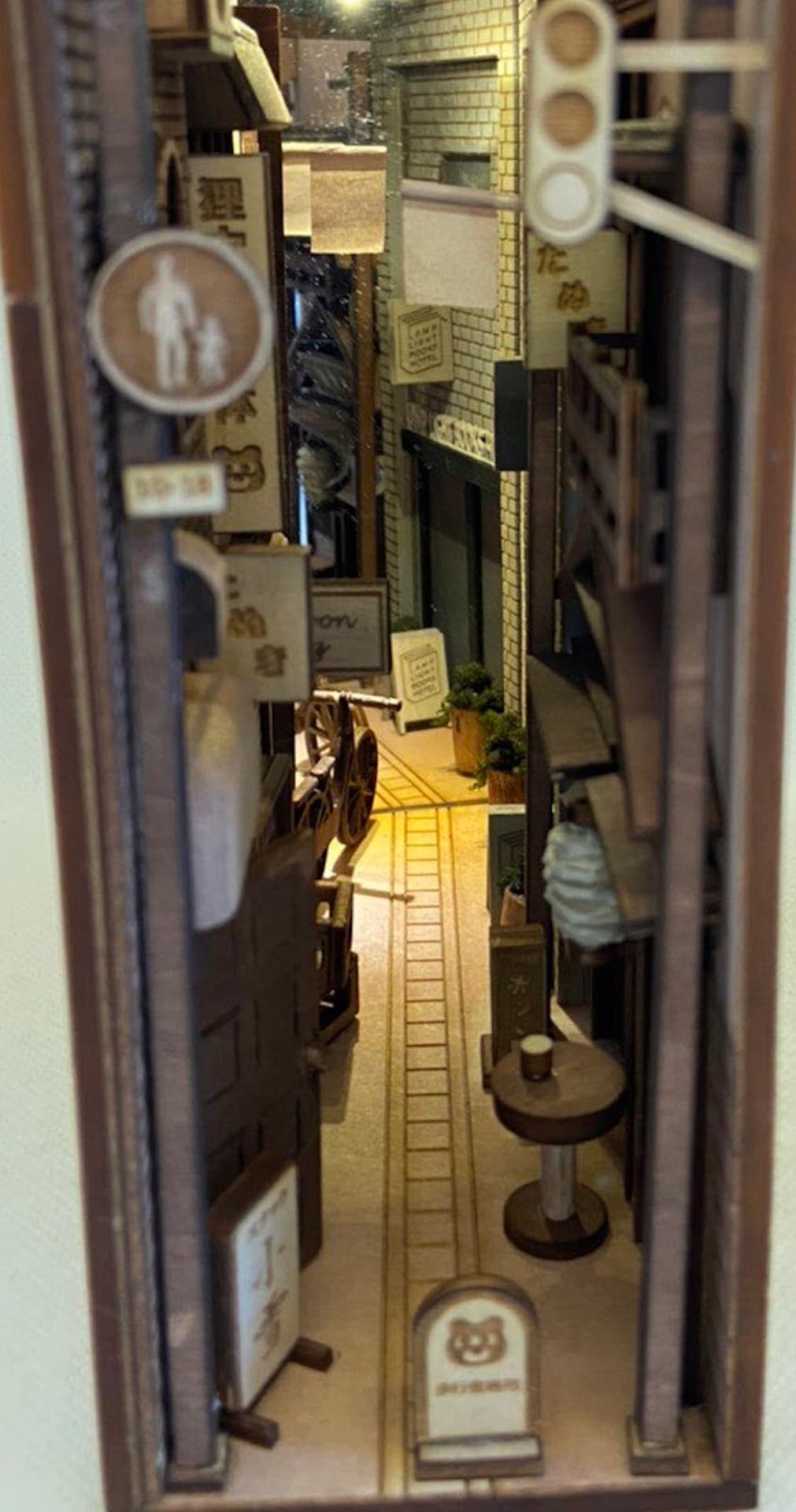 Picture of on of Monde's bookshelf inserts showing a typical narrow Tokyo alley with restaurants and shops with signs out front.