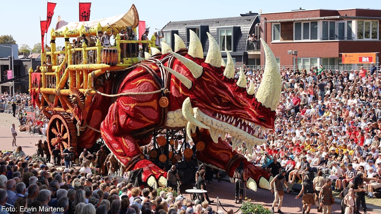 Zundert Flower Parade float made entirely of red and white Dahlias showing a horned dragon pulling a cart.