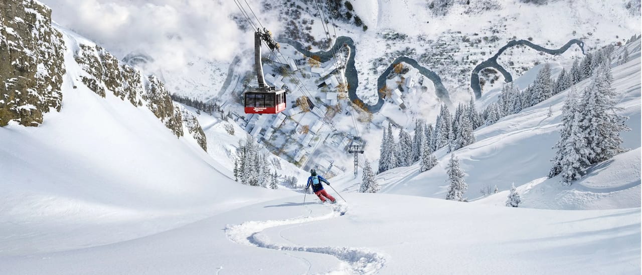Wide Electric Art Dreamscapes panorama of a skier carving powder toward the Jackson Hole tram and a folded winter valley